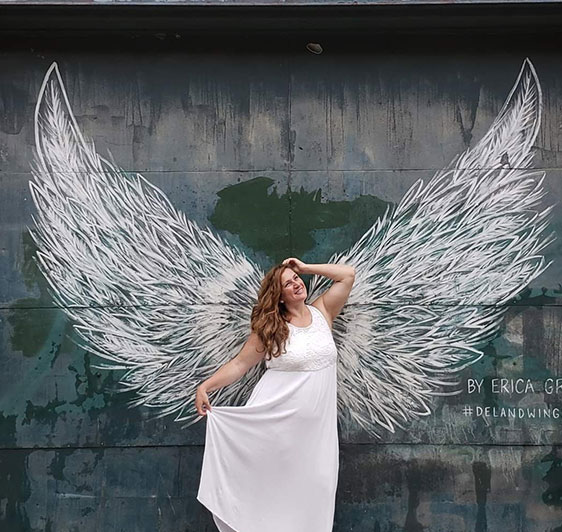 Motivational Women standing in front of wall with confidence